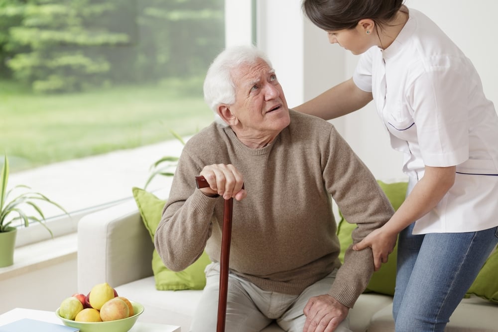 rie en zorg Young woman helping old man to stand up